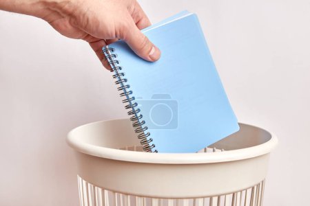Téléchargez les photos : Un carnet d'affaires usagé est jeté à la poubelle. Élimination et recyclage du papier. - en image libre de droit