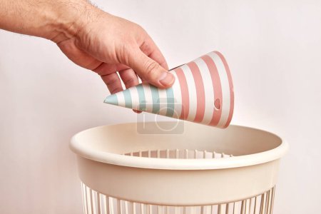 Téléchargez les photos : Le cône de fête utilisé est jeté à la poubelle. Élimination et recyclage du papier. - en image libre de droit