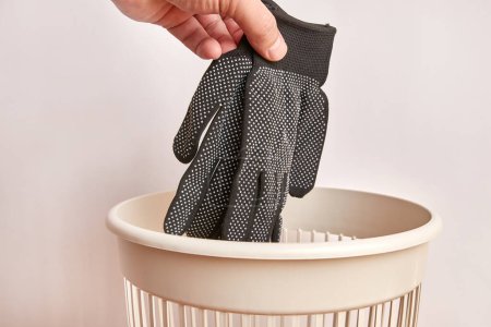 Téléchargez les photos : Des gants sont jetés à la poubelle. Élimination et recyclage des vêtements. - en image libre de droit