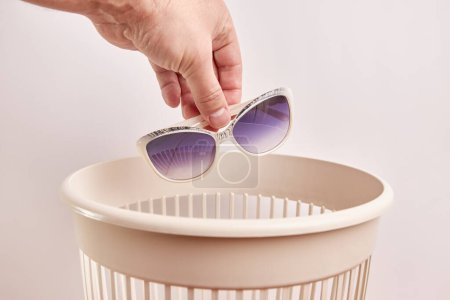 Photo for Plastic sunglasses are thrown into the trash. Disposal and recycling of plastic. - Royalty Free Image