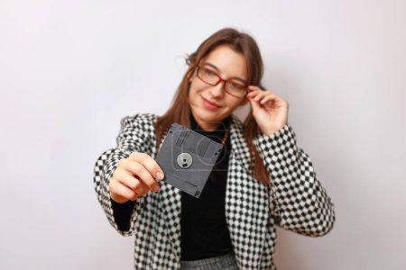 Photo for A beautiful, smiling girl in glasses holds an FDD in her hand. - Royalty Free Image