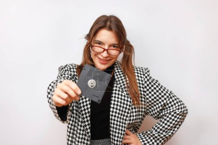 Photo for A beautiful, smiling girl in glasses holds an FDD in her hand. - Royalty Free Image