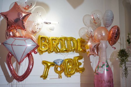Foto de Habitación decorada festivamente para una despedida de soltera con pelotas, accesorios y la inscripción "Ser una novia" - Imagen libre de derechos