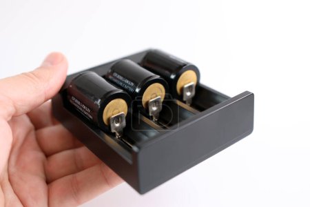 Téléchargez les photos : Chargeur avec batteries insérées pour la charge. Alimentation des gadgets ménagers. - en image libre de droit