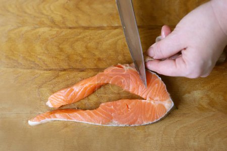 The skin is cut from the salmon steak.