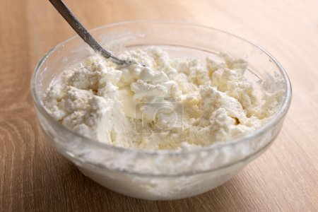 Foto de La crema agria se añade al queso de leche agria y se mezcla. - Imagen libre de derechos