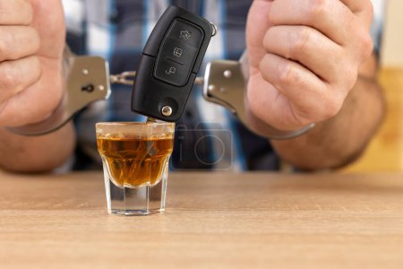 Ein Glas Alkohol und Autoschlüssel. Das Konzept des Fahrens unter Alkoholeinfluss.