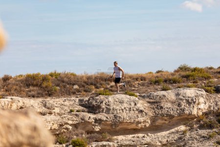 Foto de Un hombre con canas corre y hace ejercicios en el campo para mantenerse en forma y llevar un estilo de vida saludable - Imagen libre de derechos