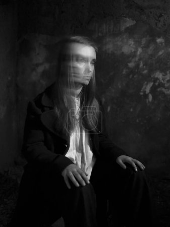 Photo for A young woman remains seated while turning her head, creating a blurred trail, conveying the idea of a split personality or the different facets of people - Royalty Free Image
