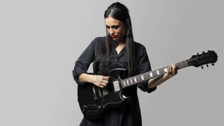 Téléchargez les photos : Une jeune femme, au look rocker, musicienne et guitariste, aime jouer de la guitare électrique - en image libre de droit