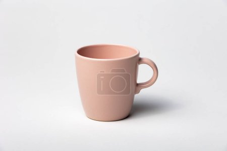 Foto de Burla de una taza de té o taza de café, color rosa, aislado, sobre un fondo liso, listo para superponer diseños o logotipos para merchandising - Imagen libre de derechos
