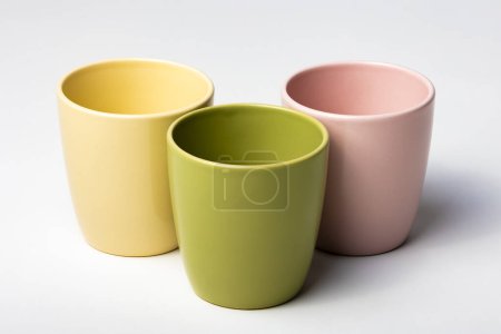 Foto de Burla de tres tazas de café de colores, o macetas, aisladas, coloridas, perfectas para diseños de superposición o logotipos para merchandising - Imagen libre de derechos