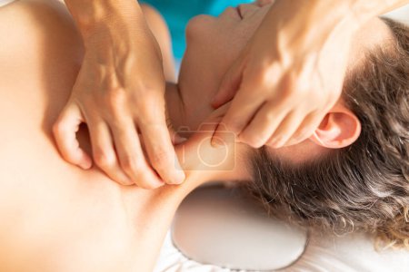Foto de Una fisioterapeuta masajea el músculo esternocleidomastoideo en el cuello de su paciente para disminuir la tensión y el dolor - Imagen libre de derechos