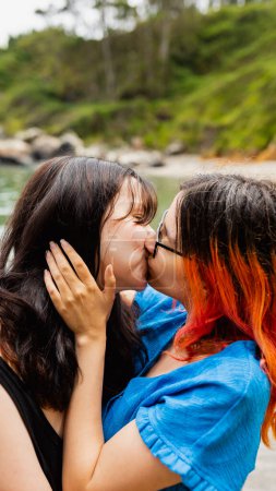 Téléchargez les photos : Deux jeunes filles lesbiennes s'embrassent passionnément, sur une plage naturelle en été - en image libre de droit