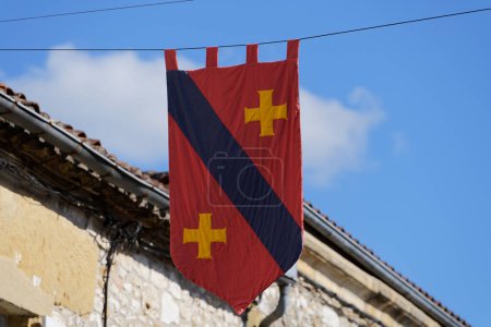 Photo for Red medieval flag hanging in the sky in Monpazier, Dordogne - Royalty Free Image