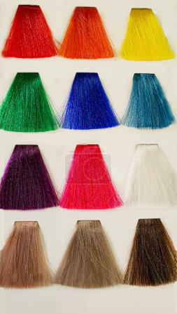 Foto de Una paleta de colores de pelo hechos de hebras artificiales sobre un fondo blanco. Selección de color. Copiar espacio - Imagen libre de derechos