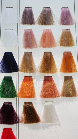Foto de Una paleta de colores de pelo hechos de hebras artificiales sobre un fondo blanco. Selección de color. Copiar espacio - Imagen libre de derechos