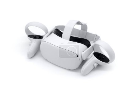 Téléchargez les photos : Casque de réalité virtuelle avec télécommandes isolées sur fond blanc - en image libre de droit