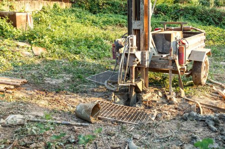 Photo for Drilling rig for drilling water wells and producing drinking water for residential premises. Pumping dirty water out of the well - Royalty Free Image
