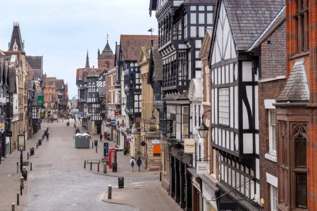 Photo for CHESTER, GREAT BRITAIN - SEPTEMBER 14, 2014: This is a historic Eastgate Street in the center of a medieval town with half-timbered and stone houses in a semi-detached building. - Royalty Free Image