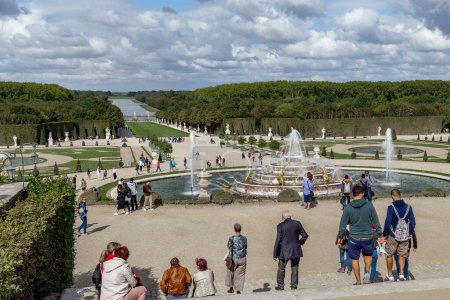 Photo for VERSAILLES, FRANCE - SEPTEMBER 8, 2018: Unidentified people admiring the prospect of the main avenue at the working fountain of the Parterre Latona in the palace park on an autumn evening. - Royalty Free Image