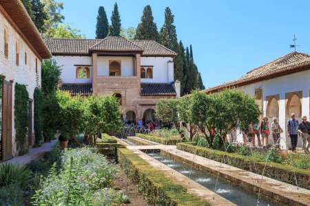 Photo for GRANADA, SPAIN - MAY 20, 2017: Unidentified tourists inspect the Guest House and patio with irrigation ditches in the Generalife Gardens. - Royalty Free Image