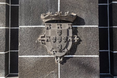 Foto de FUNCHAL, PORTUGAL - AUGUST 20, 2021: This is a fragment with a relief with the coat of arms of Portugal on the pedestal of the Statue Infante. - Imagen libre de derechos