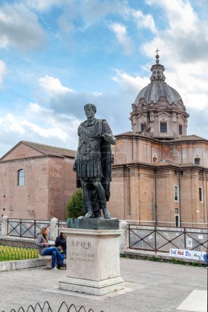 Photo for ROME, ITAMY - MARTH 8, 2023: This is a statue of the ancient Roman emperor Julius Caesar against the backdrop of the Church of the Holy Martyrs Luke and Martina. - Royalty Free Image