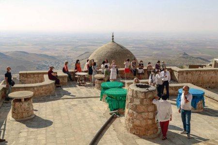 Téléchargez les photos : MARDIN, TURQUIE - 10 OCTOBRE 2020 : Il s'agit d'un groupe de touristes non identifiés sur le toit-terrasse de l'ancien sauna Emir Hamami surplombant la plaine syrienne. - en image libre de droit