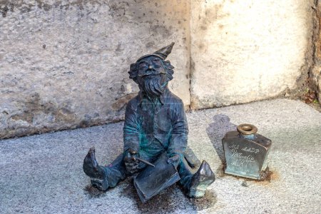 Téléchargez les photos : WROCLAW, POLOGNE - 4 NOVEMBRE 2023 : Il s'agit d'une figurine en bronze symbolique d'un gnome Chronicler dans une rue de la ville. - en image libre de droit