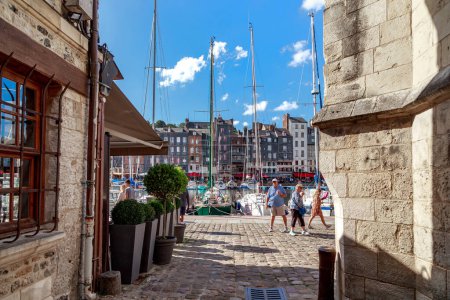 Photo for HONFLEUR, FRANCE - SEPTEMBER 1, 2019: This is the passage from a narrow medieval alley to the Saint-Etienne embankment to the yacht piers. - Royalty Free Image