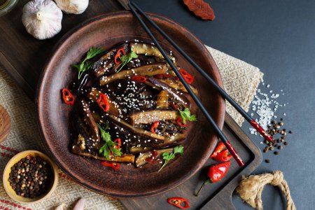Foto de Berenjena china en salsa agridulce en un plato oscuro. antecedentes alimentarios - Imagen libre de derechos