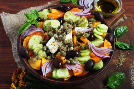 Photo for Classic Greek salad with yellow tomatoes, cucumbers, olives, capers and soft cheese. Close-up photo - Royalty Free Image