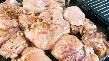 Alimentación saludable, cocinar aves de corral en una parrilla eléctrica, con varias especias