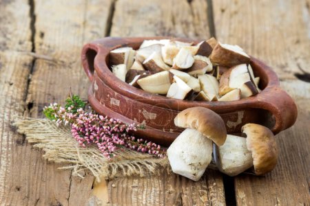 fresh mushrooms (boletus) in a bowl on wooden background