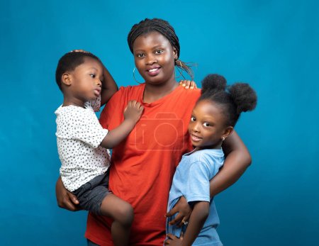 Foto de Familia africana feliz de Nigeria que consiste en una madre, tía o tutor, llevando a los niños, un niño y niña en sus manos - Imagen libre de derechos