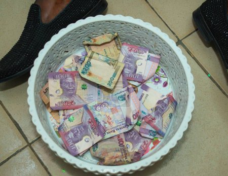 Photo for Different denomination of Naira notes, money or currency in a small plastic basket being collected during a traditional wedding party in Nigeria - Royalty Free Image