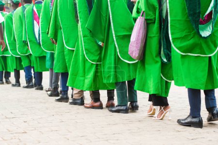 Foto de Line up of university graduating students wearing their green graduation outfit and marching towards the school reception hall for their pass out ceremony in Nigeria - Imagen libre de derechos