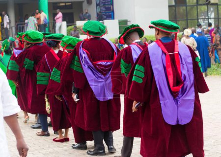 Photo for Line up of university graduating students wearing their green graduation outfit and marching towards the school reception hall for their pass out ceremony in Nigeria - Royalty Free Image
