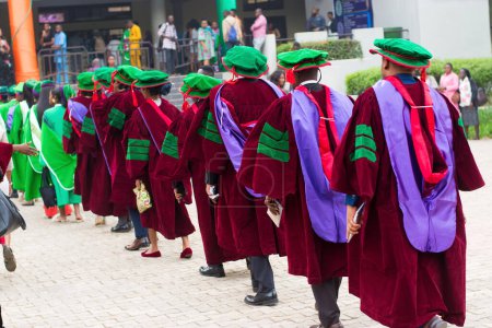 Foto de Line up of university graduating students wearing their green graduation outfit and marching towards the school reception hall for their pass out ceremony in Nigeria - Imagen libre de derechos