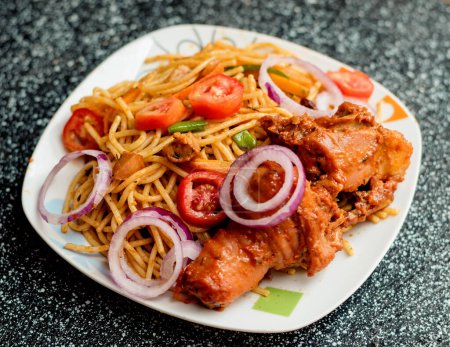 Photo for An assorted delicious dish of spaghetti noodles and chicken meat, garnished with sliced onions and tomatoes among other mouth watering food ingredients and spices cooked in Nigeria - Royalty Free Image