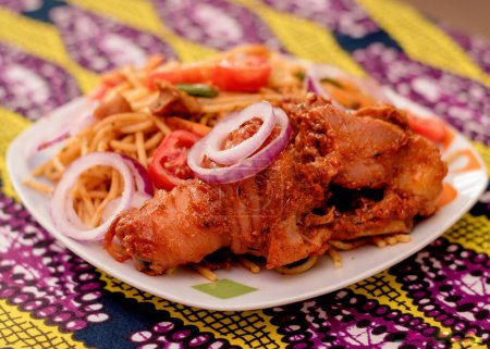 Photo for An assorted delicious dish of spaghetti noodles and chicken meat, garnished with sliced onions and tomatoes among other mouth watering food ingredients and spices cooked in Nigeria - Royalty Free Image