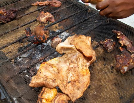 Photo for Close up shot of a African barbeque and grilling machine with different parts goat meat laid on the net at an event in Nigeria - Royalty Free Image
