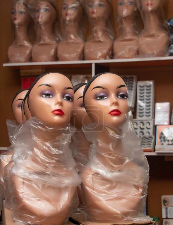 Téléchargez les photos : Mannequin multiple avec filet à cheveux affiché côte à côte pour les ventes dans un salon et boutique de mode au Nigeria - en image libre de droit