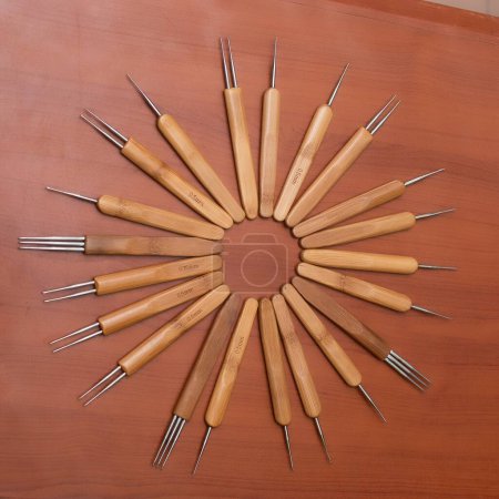 Foto de Múltiples herramientas de ganchillo pelo de madera formando una forma de círculo redondo en una mesa de madera contrachapada en un salón y tienda de ventas de negocios de moda en Nigeria - Imagen libre de derechos