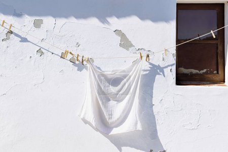 Téléchargez les photos : Fenêtre et vêtements suspendus. Façade murale vieille maison à Mertola, Portugal. Couleurs du Portugal Série - en image libre de droit
