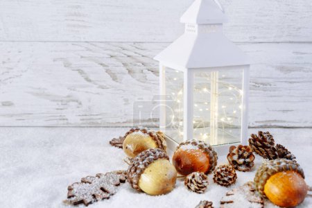 Téléchargez les photos : Lanterne de Noël sur neige avec glands et feuilles de chêne. Scène de Noël. - en image libre de droit