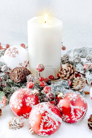 Photo for Christmas decorations. White burning candle with red baubles - Royalty Free Image