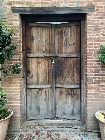 Puerta de madera envejecida con viejos efectos de película. Puerta de madera adornada vieja marrón con tallas hermosas en la ciudad amurallada de Lahore, Pakistán.