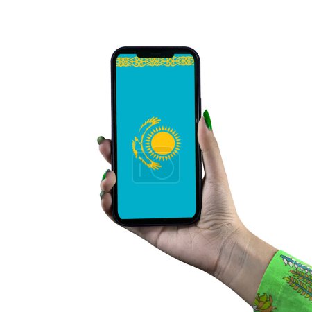 Foto de La bandera de Kazajstán se muestra en un teléfono inteligente sostenido por una joven mujer o mujer asiática de la mano. Patriotismo con pantalla moderna de tecnología de teléfonos celulares. Aislado sobre un fondo blanco. - Imagen libre de derechos